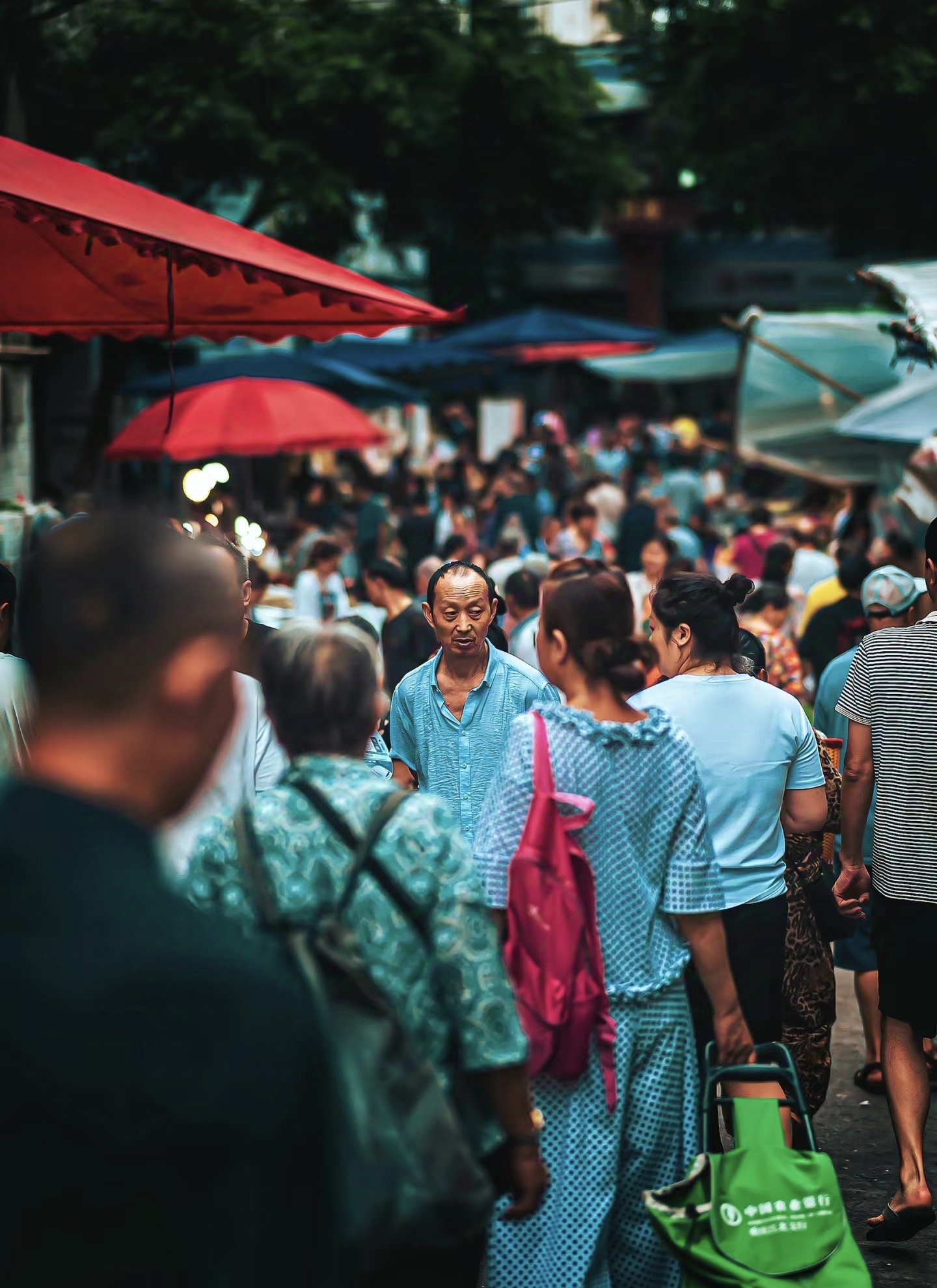 在熙熙攘攘的人群里,一个小女孩高高坐在爷爷的肩部