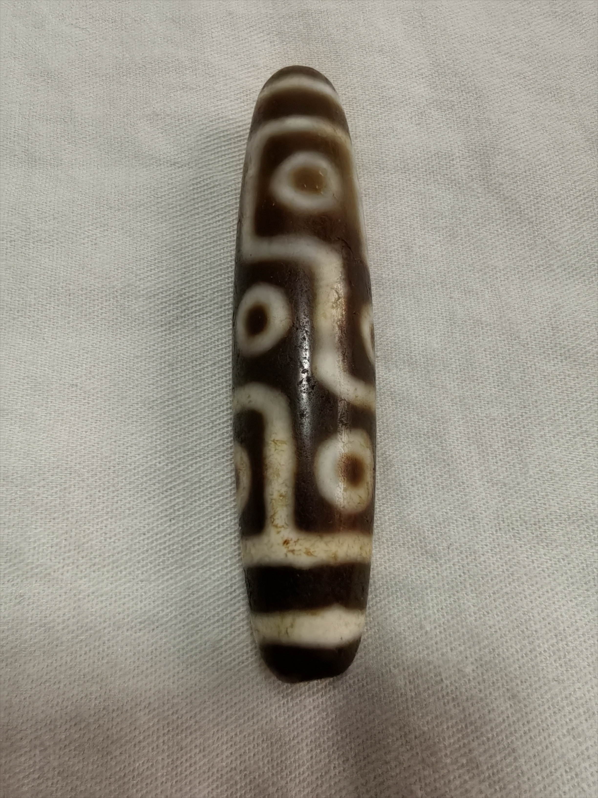 唐代九眼天珠:重14.8克,长5.8cm,肚径1.5cm.材质玛瑙秘制