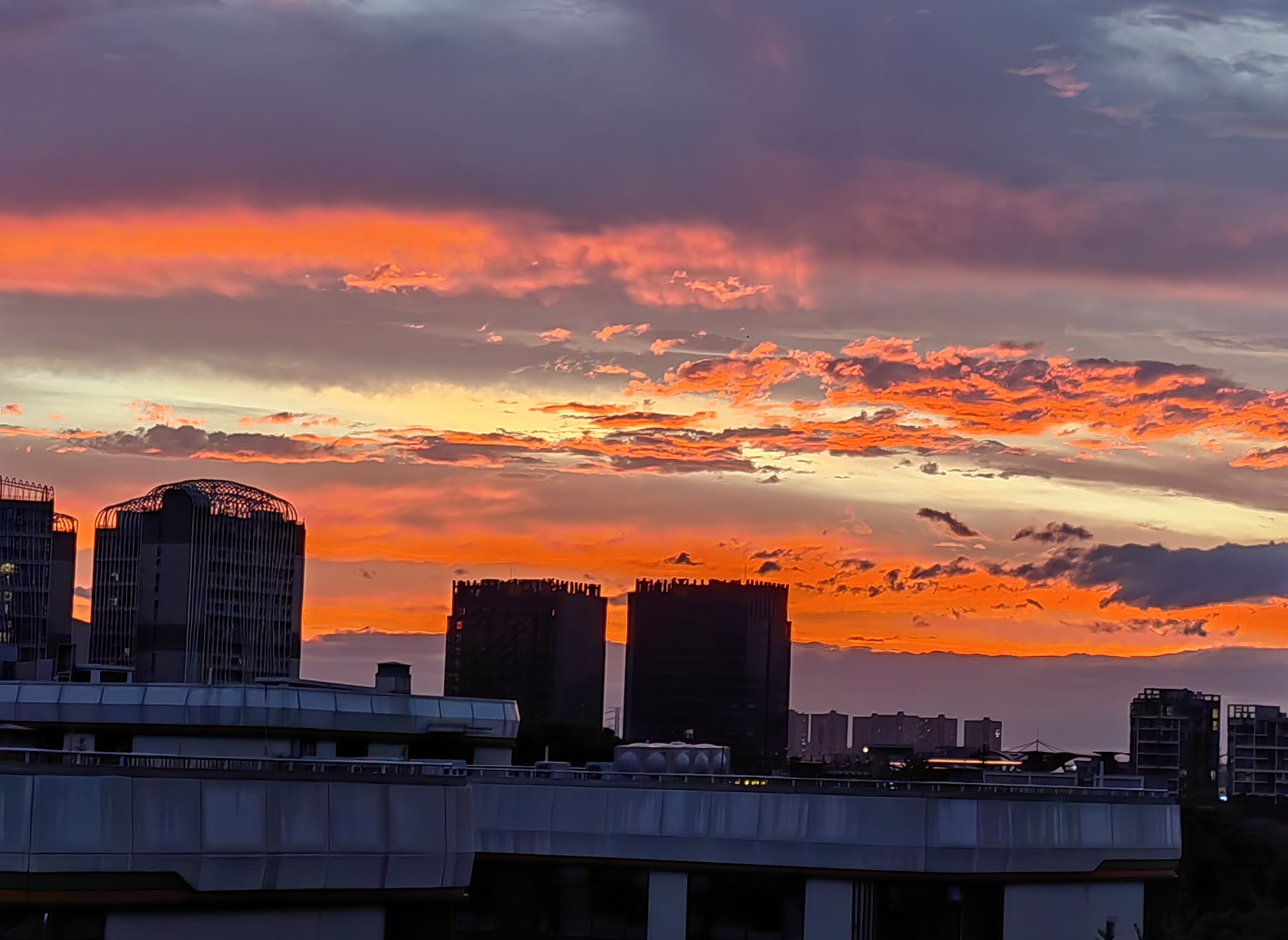 夕阳下的城市剪影,云朵像是着了火,美得让人心醉.