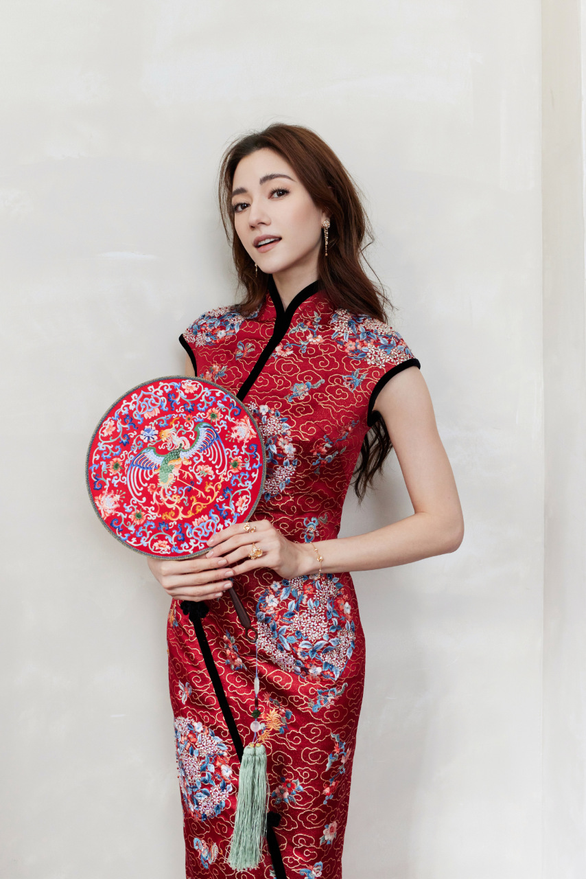 娜然身着红色秀纹旗袍,精致的立领,恰到好处的开叉,完美呈现东方女性