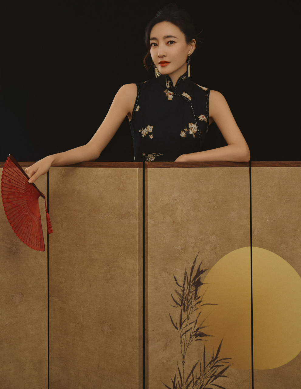 王丽坤身穿黑色绣花旗袍,充分展现东方女性的优雅与魅力,旗袍与折扇搭