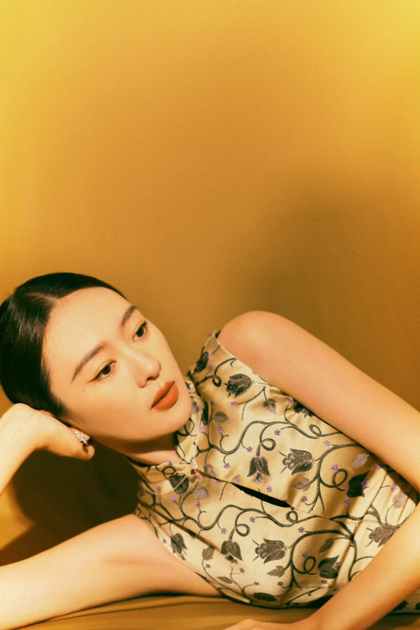 童瑶身着复古旗袍,如郁金香花枝散落于身,点缀零星紫意,诠释东方优雅