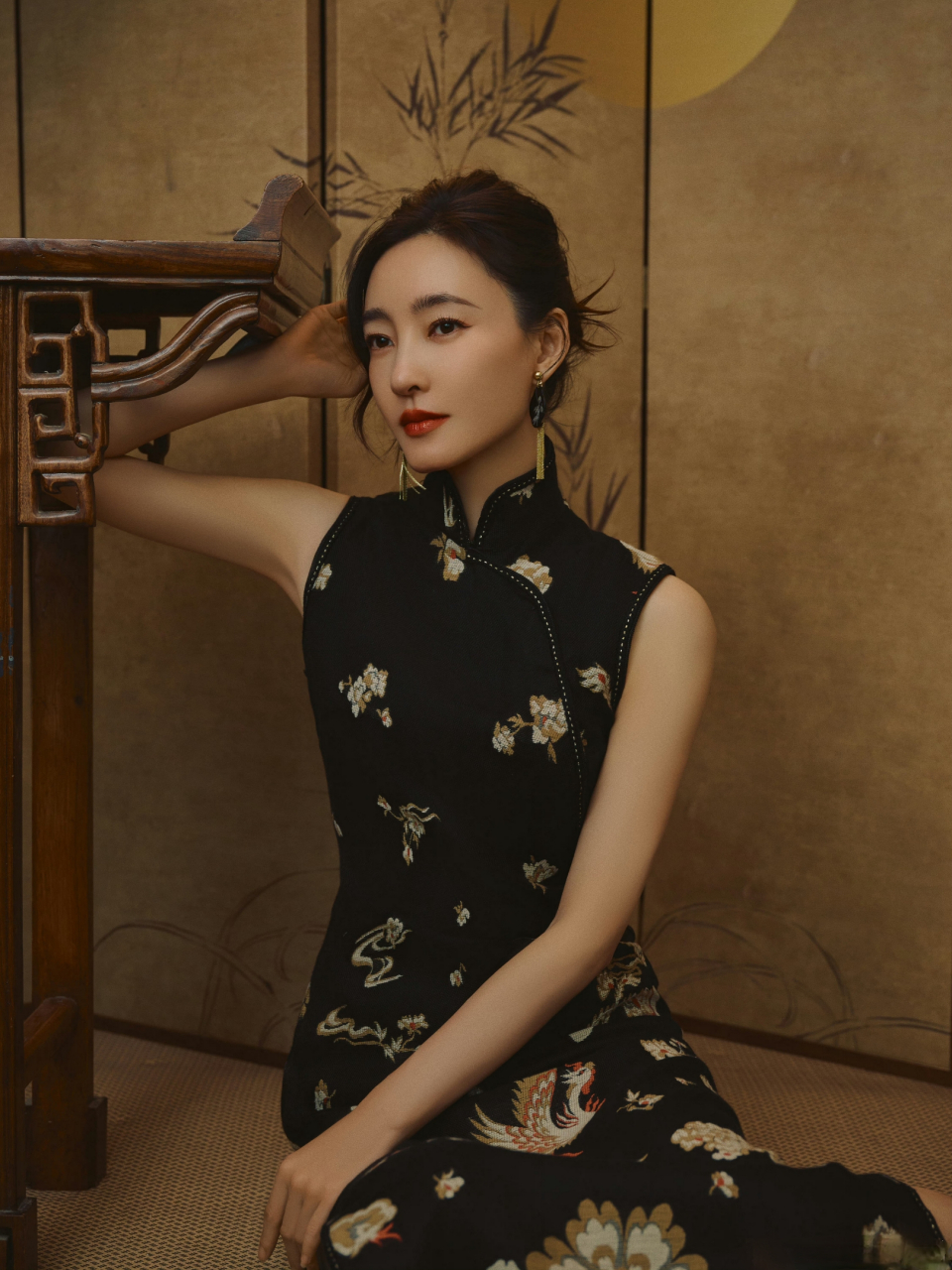 王丽坤身穿黑色绣花旗袍,充分展现东方女性的优雅与魅力,旗袍与折扇搭