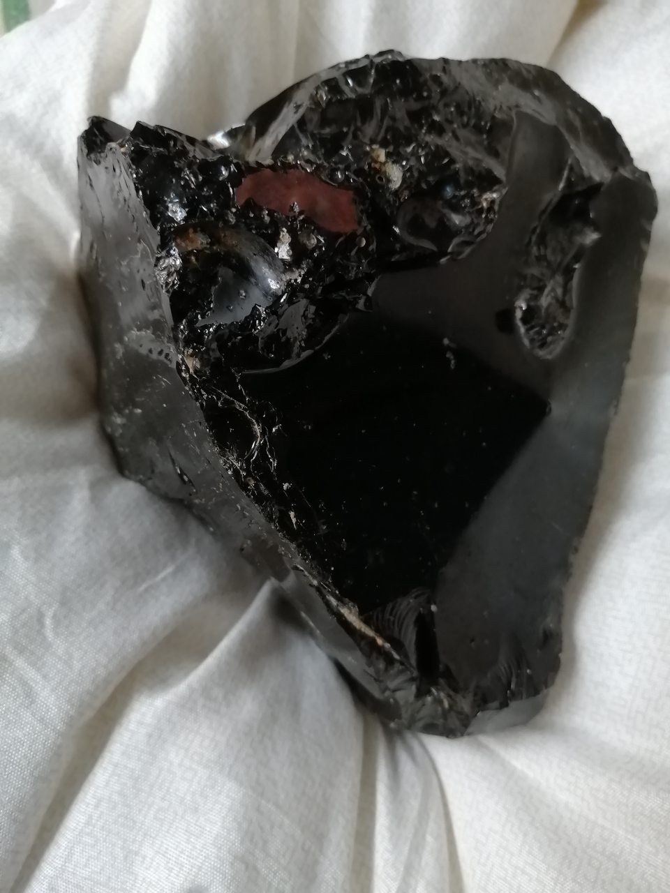 在冰土里,露出来一点点黑乎乎的玻璃样石头,仔细一瞧亮晶晶,非常剔透