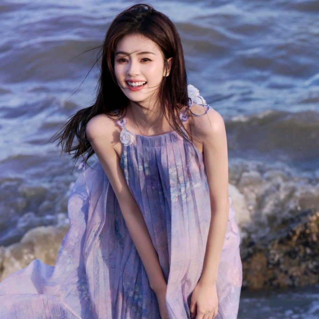 白鹿站在海边,海风吹拂着她的长发,她微笑着,仿佛整个世界都为她停留