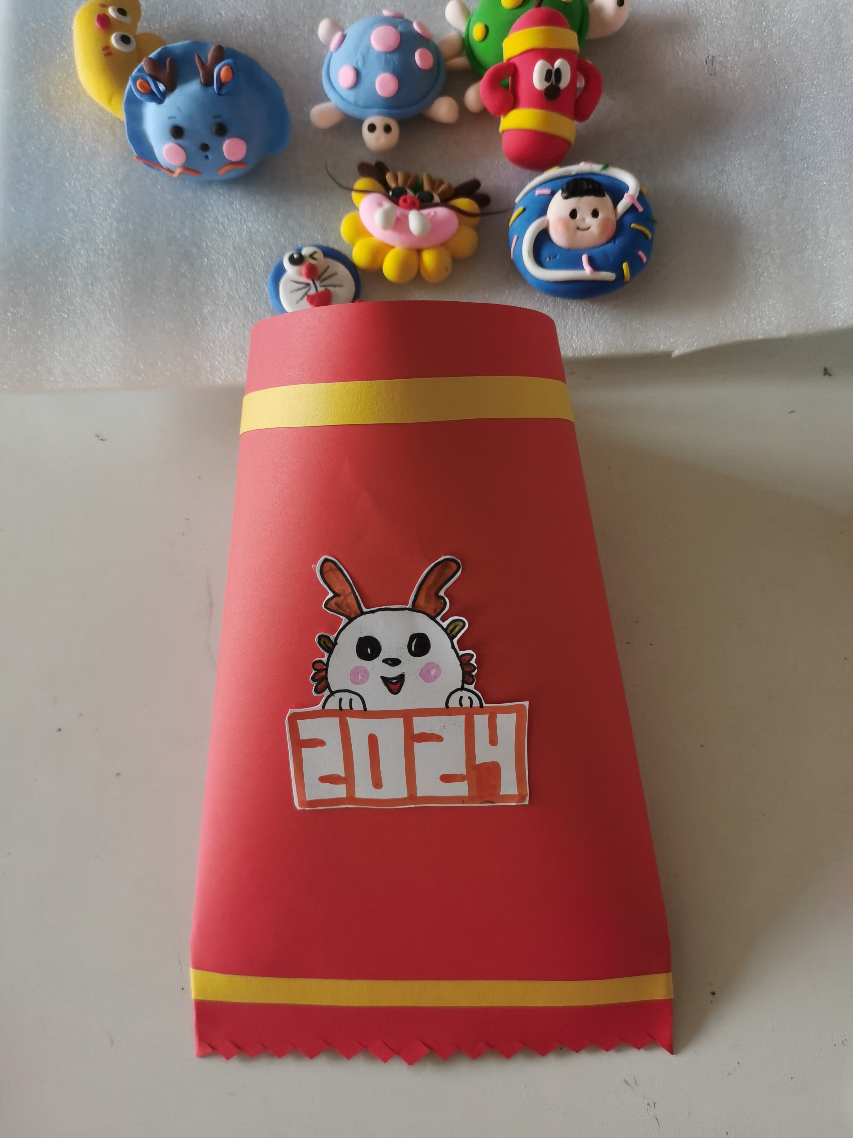 制作步骤: ①在一张a4红色卡纸上贴两道黄色长条