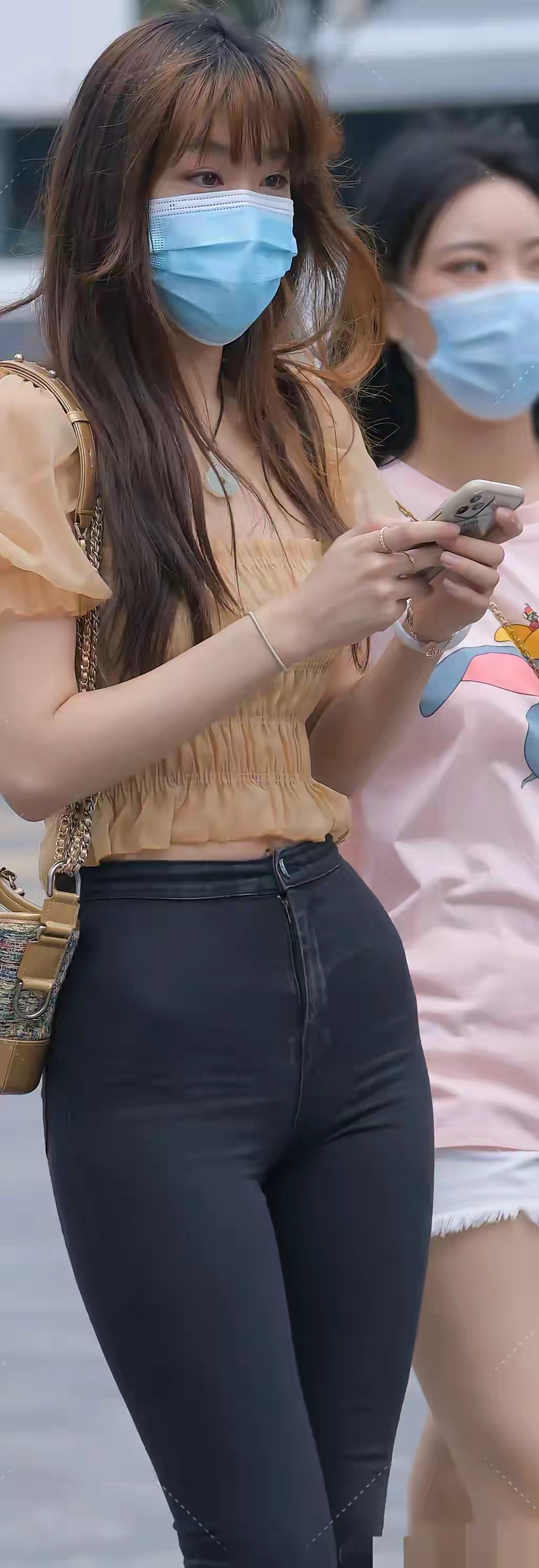 两位年轻女性在街头行走,穿搭各具特色,彰显时尚品味