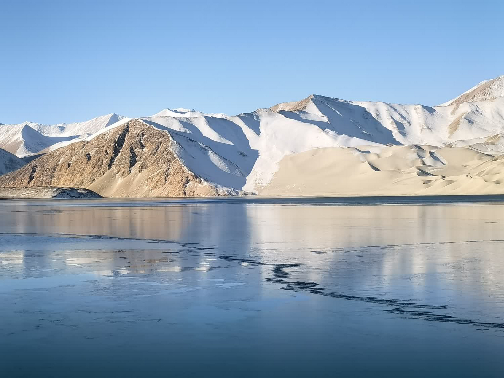 隐藏在雪山下的冰湖奇迹  臃肿的羽绒服,笨重的雪地靴,一路跋山涉水