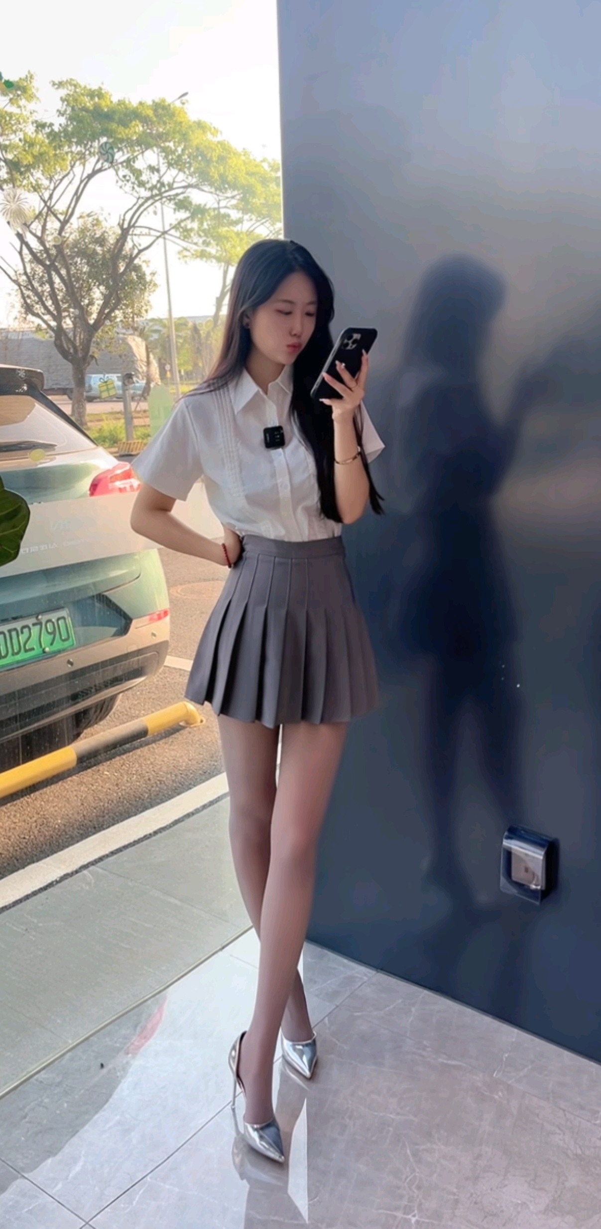 浅灰色百褶裙与超薄灰色丝袜的搭配,再配上银色光亮高跟鞋,白色t恤