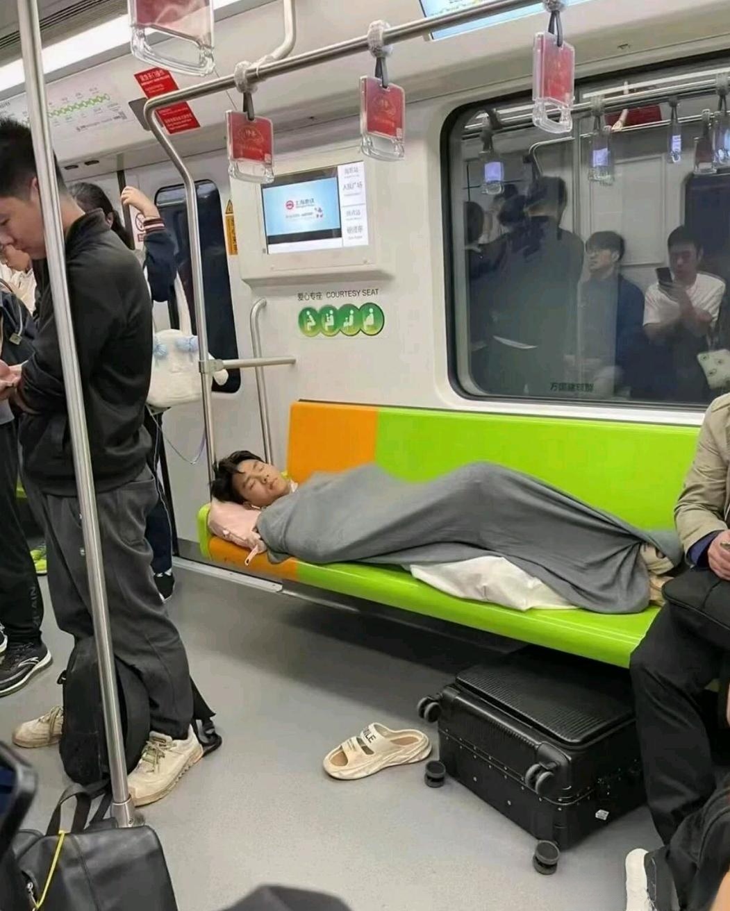 兄弟你在公共场合躺着在呼呼睡大觉,你是把地铁站当成你家吗?