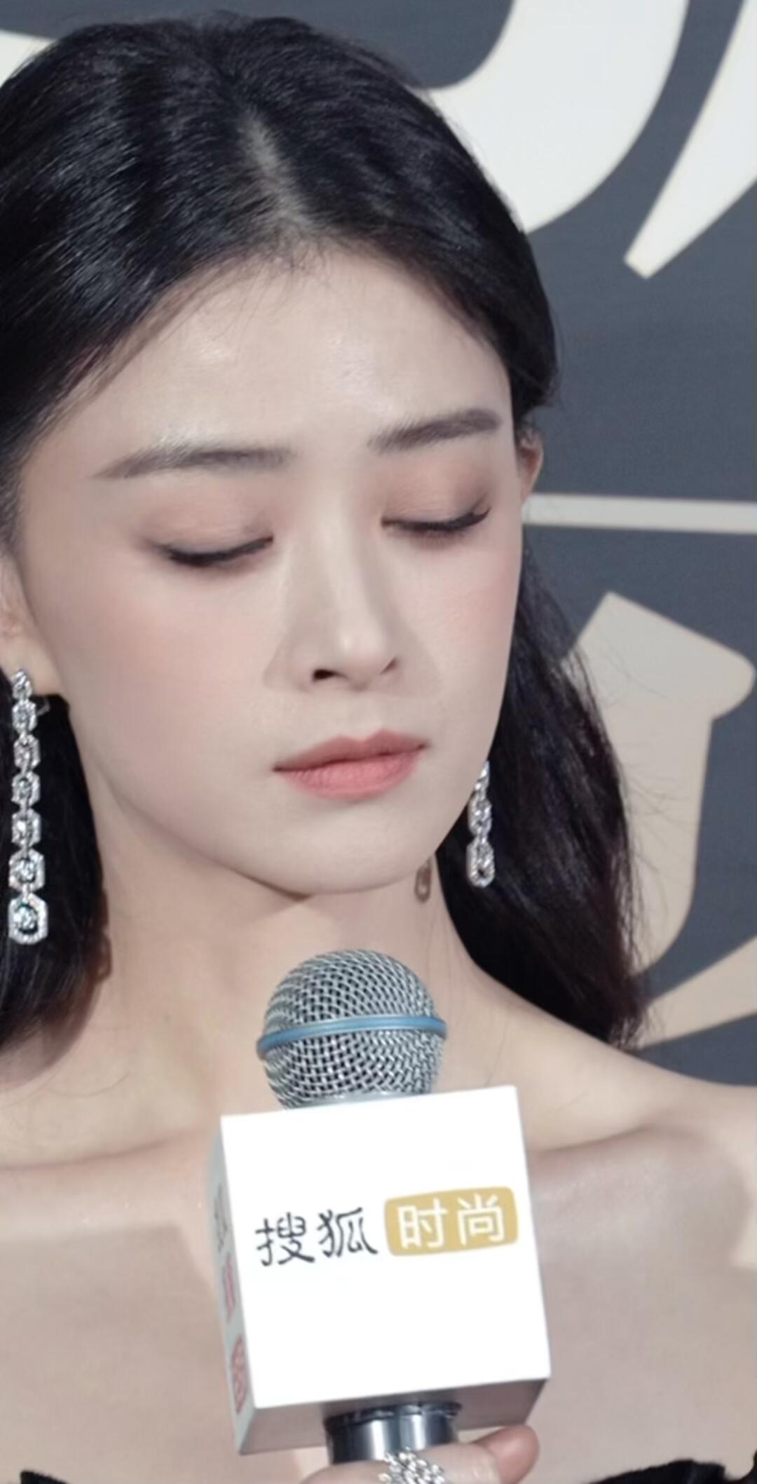 身穿黑色一字肩礼服,梳着半披发,长款耳饰恰好修饰了肩颈线条,有