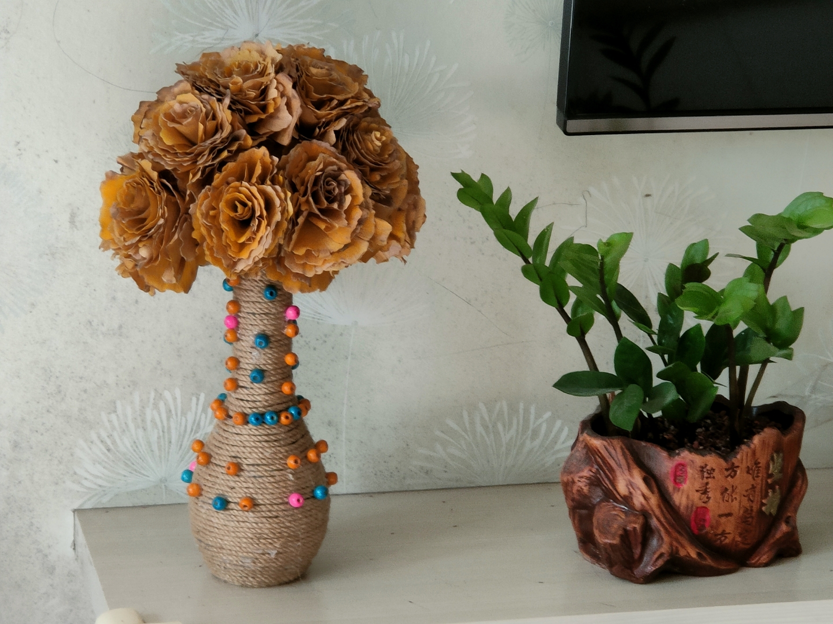 前年,我用废旧酒瓶制作了一个别致的花瓶,用百果叶子编织成一束仿真花