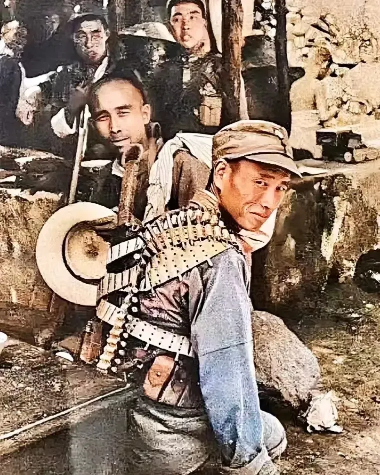 他身着军装,背上背着大刀,子弹带环绕身上