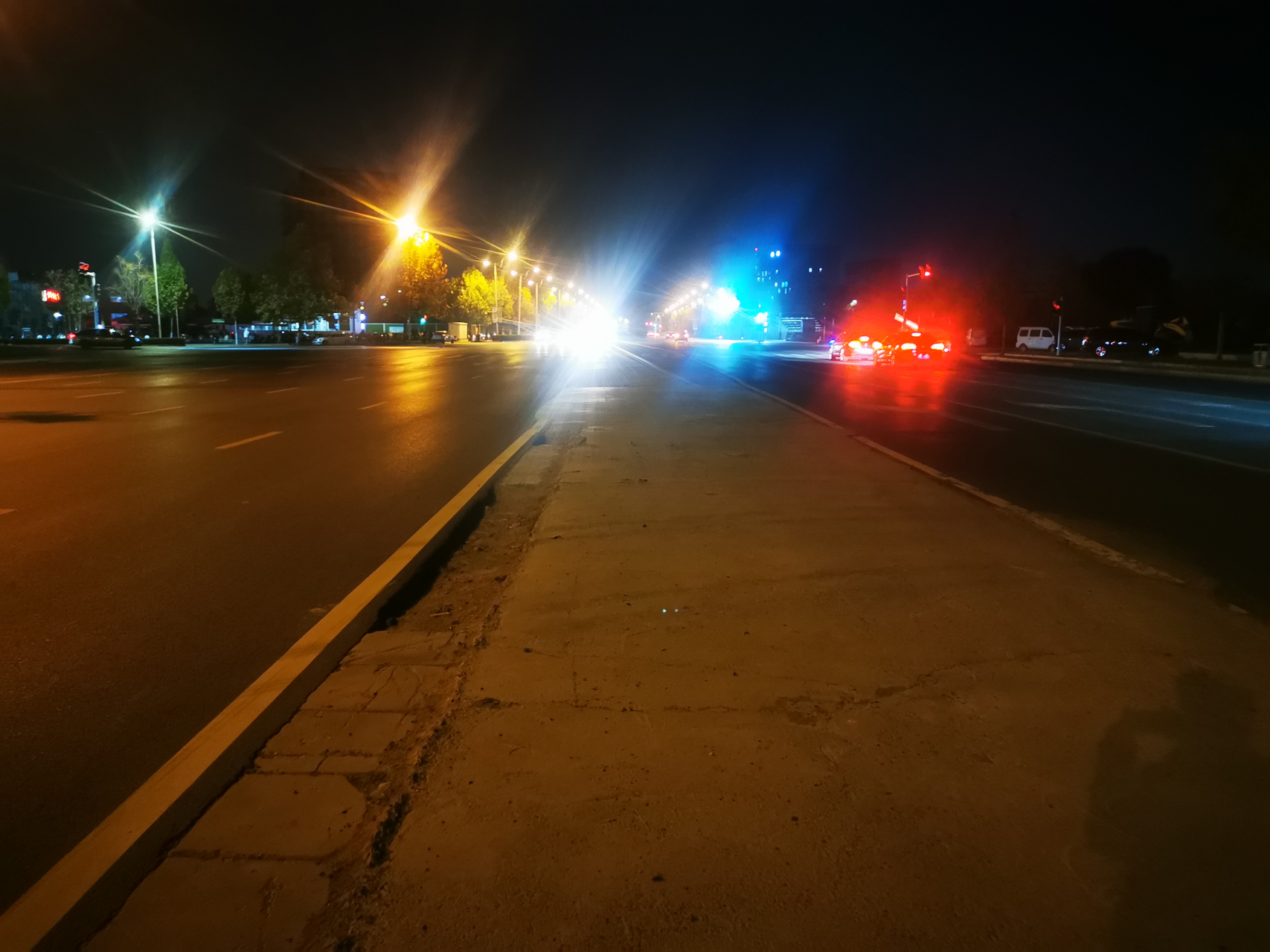 马路中间,实线外,有坑,坑内有一立起来的钢筋,造成车辆爆胎,轮毂受损