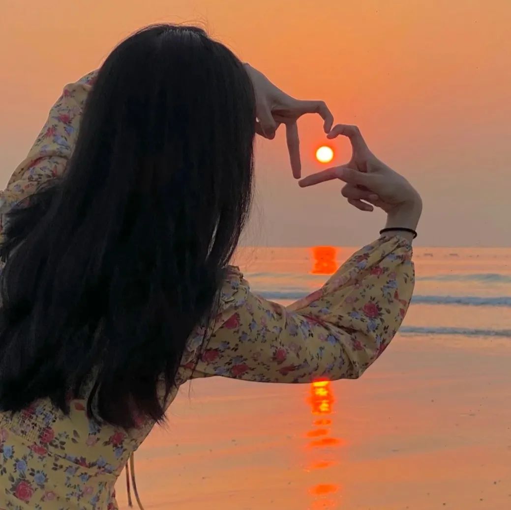 夕阳下海边的爱心剪影,是她与世界温柔的距离
