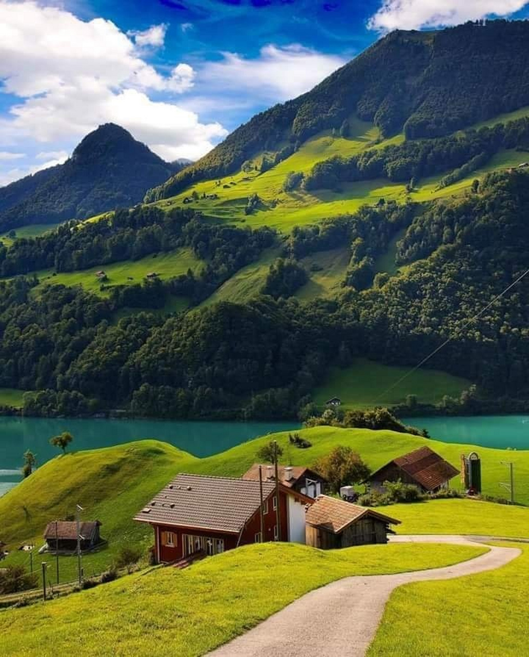 瑞士最美小镇龙疆,青草地上,棕色和红色的房屋静静地伫立,仿佛在诉说