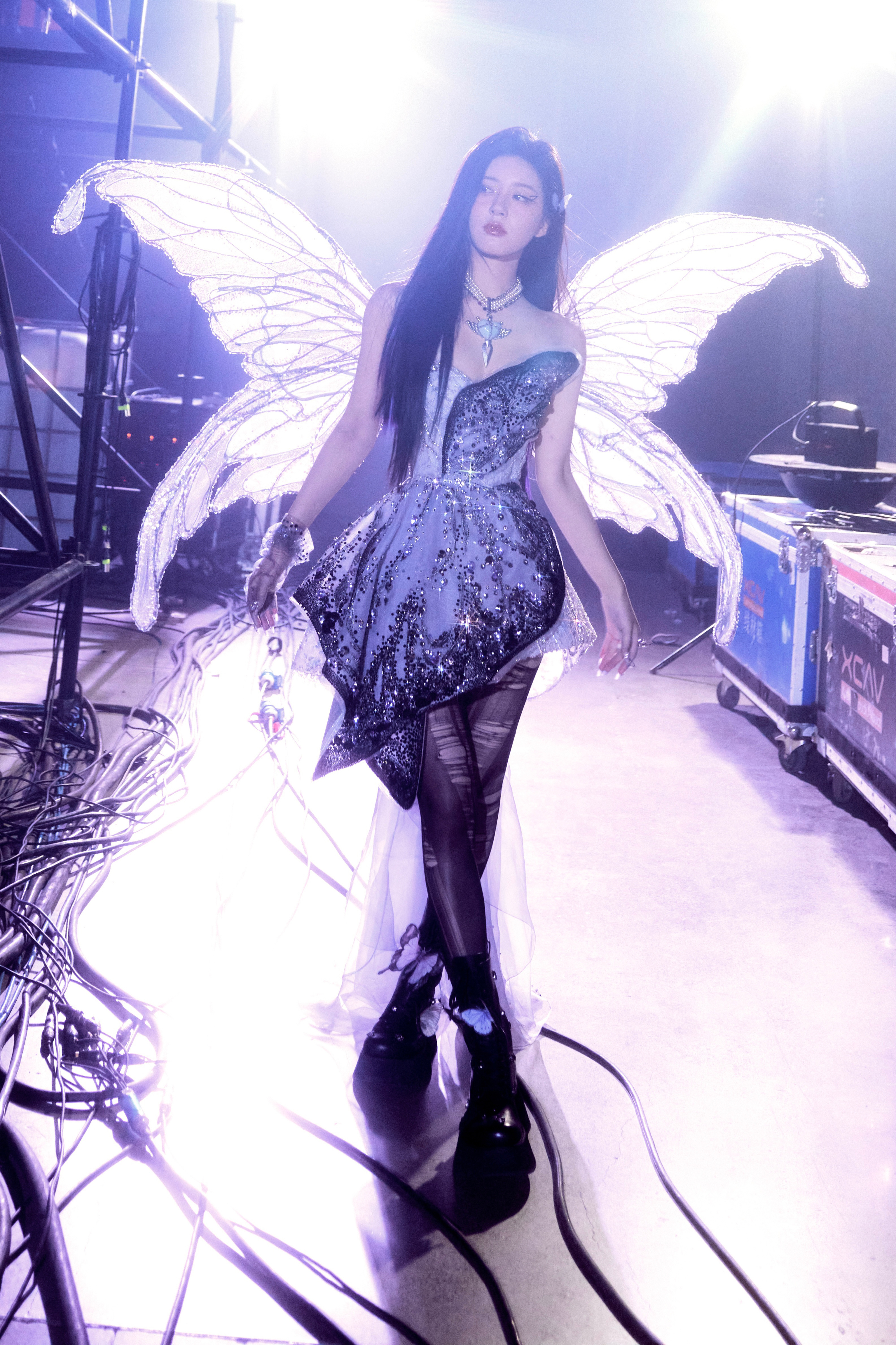 赵露思在灯光下,身着华丽的表演服,背后有一对巨大的翅膀,让她看起来