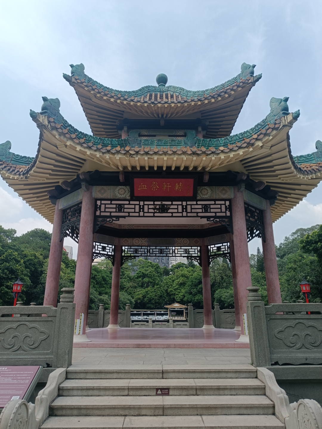 我站在公园里,惊叹于眼前这座传统的中国亭子,它的飞檐翘角和红柱绿瓦