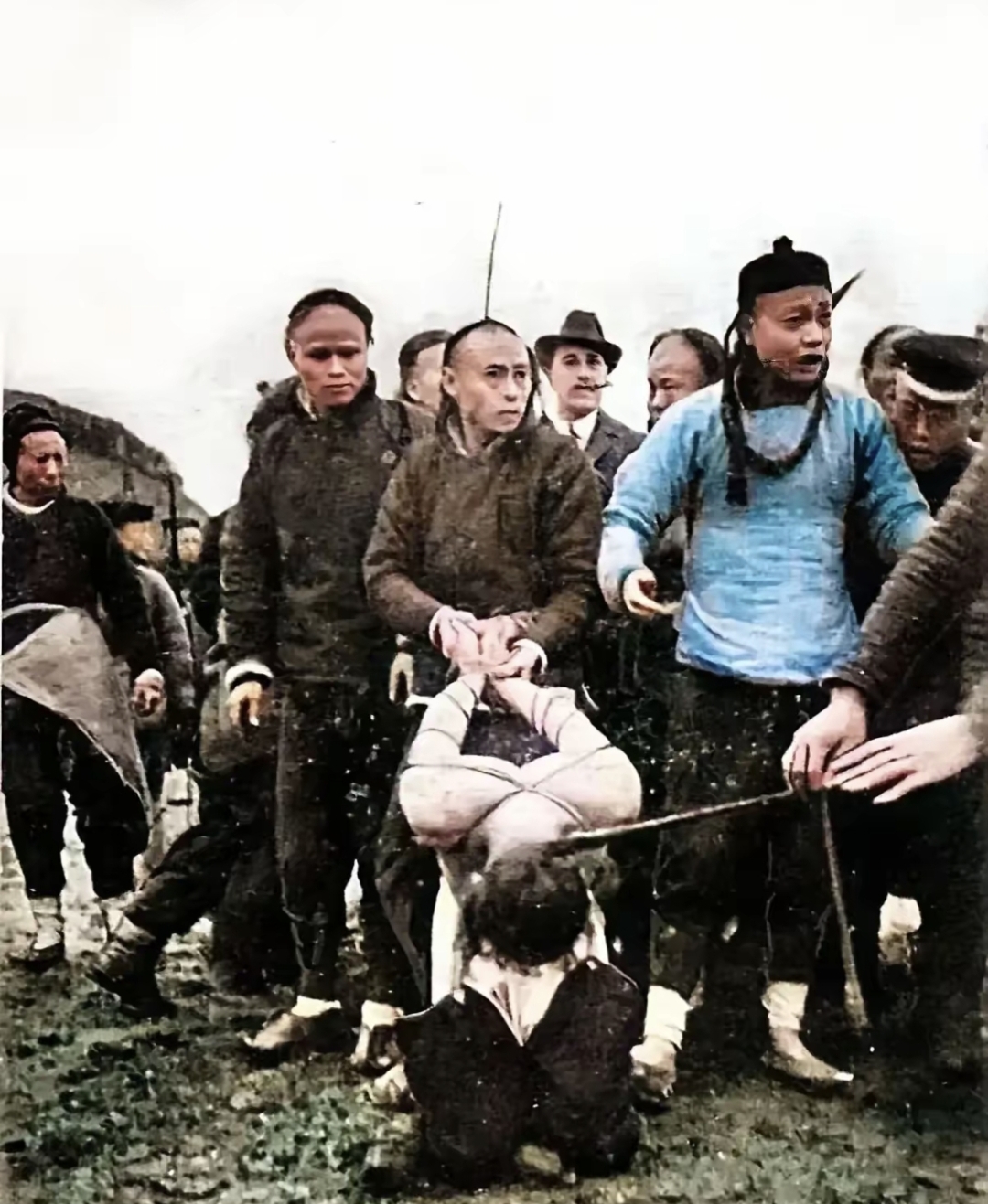 一人反制压着他的手,另一人则向扯着他的辫子,刽子手马上就要行刑了