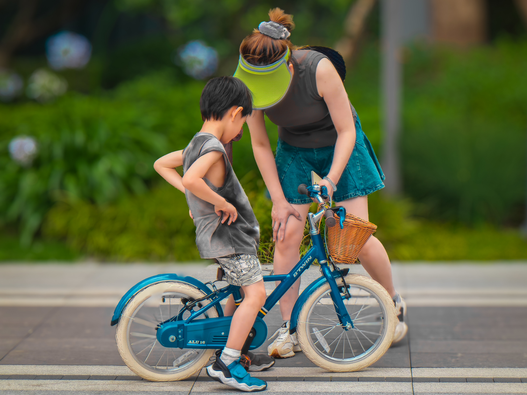 母子情深,母亲正在向学骑自行车的孩子教授学习自行车稳定的要领.