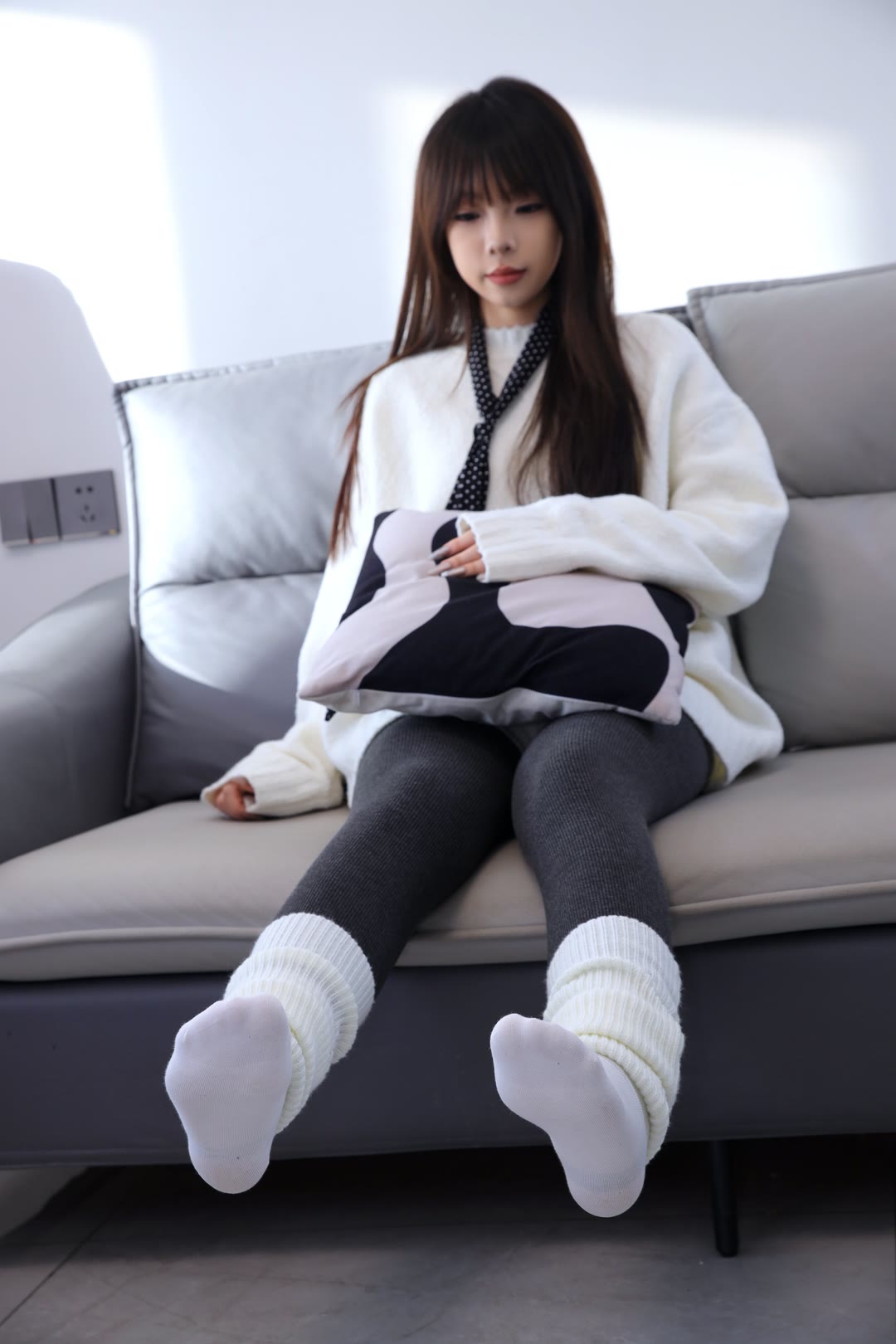 白色的袜子配上黑色的裤子,再搭上一件毛茸茸的白毛衣,就那么坐着