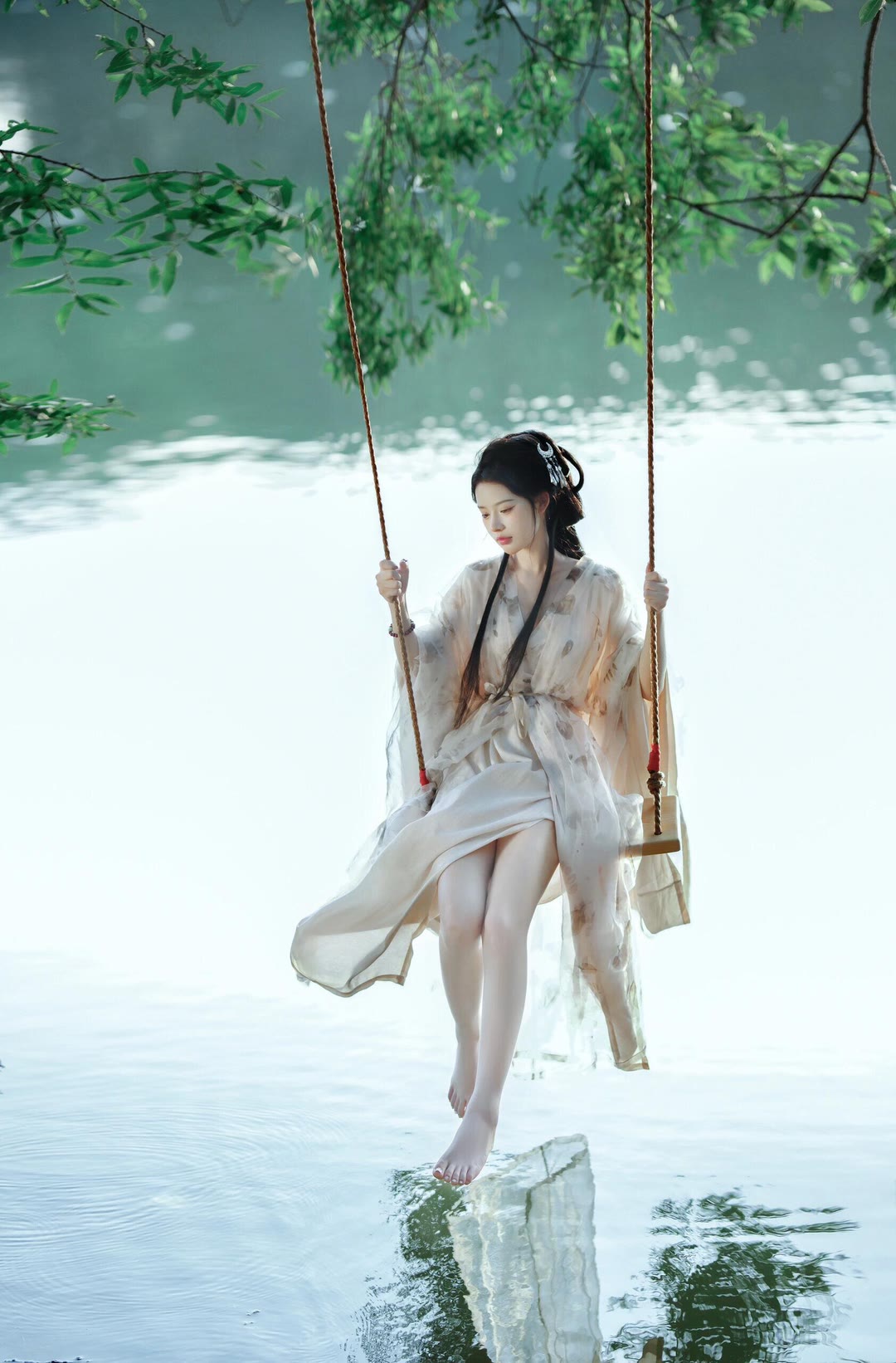 穿着汉服,光着脚丫,在湖边的树下荡秋千