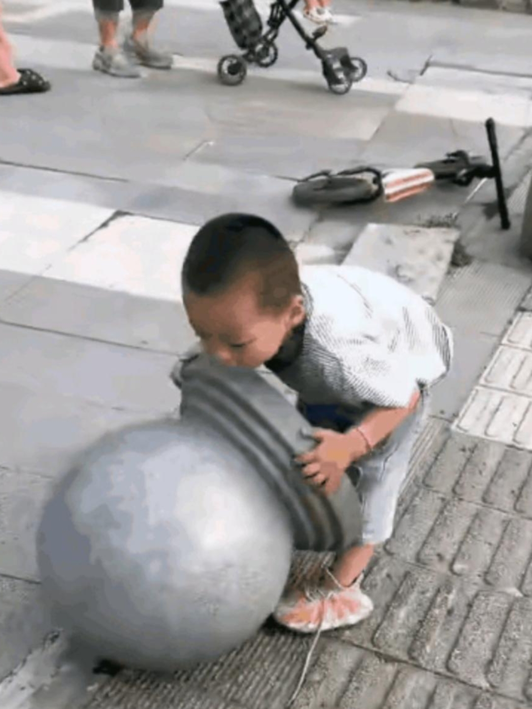 我今天推着孙子正好路过一个小区,在小区门口一个小男孩玩起了大力士