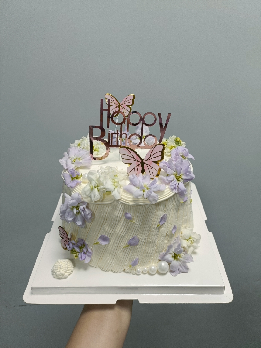 哇,这生日蛋糕也太美了吧,奶油和鲜花,水果装饰得真精致,好像艺术品一