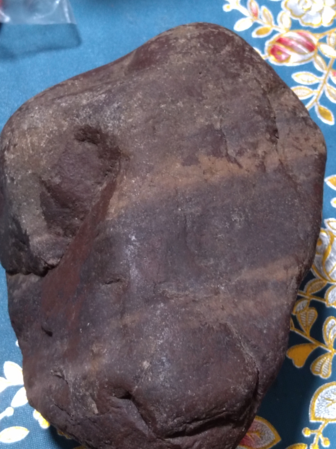 这是一块紫红色的石头,紫红色的容壳大部分还没有脱落,无磁性,260多 