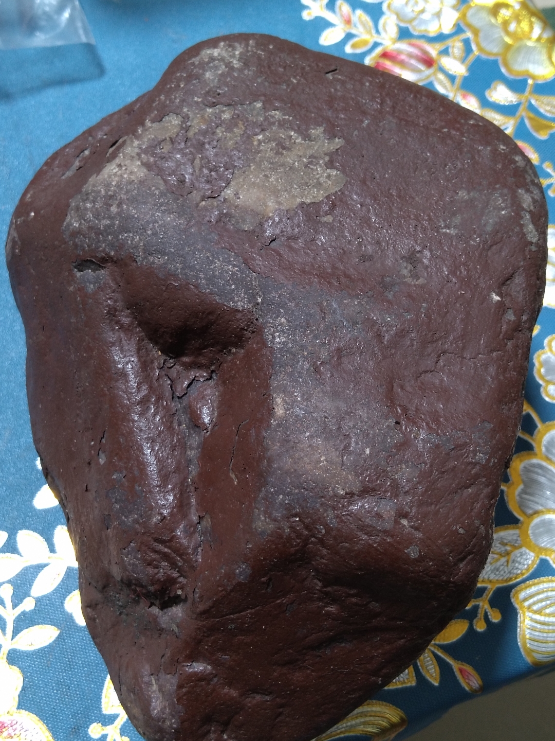 这是一块紫红色的石头,紫红色的容壳大部分还没有脱落,无磁性,260多 