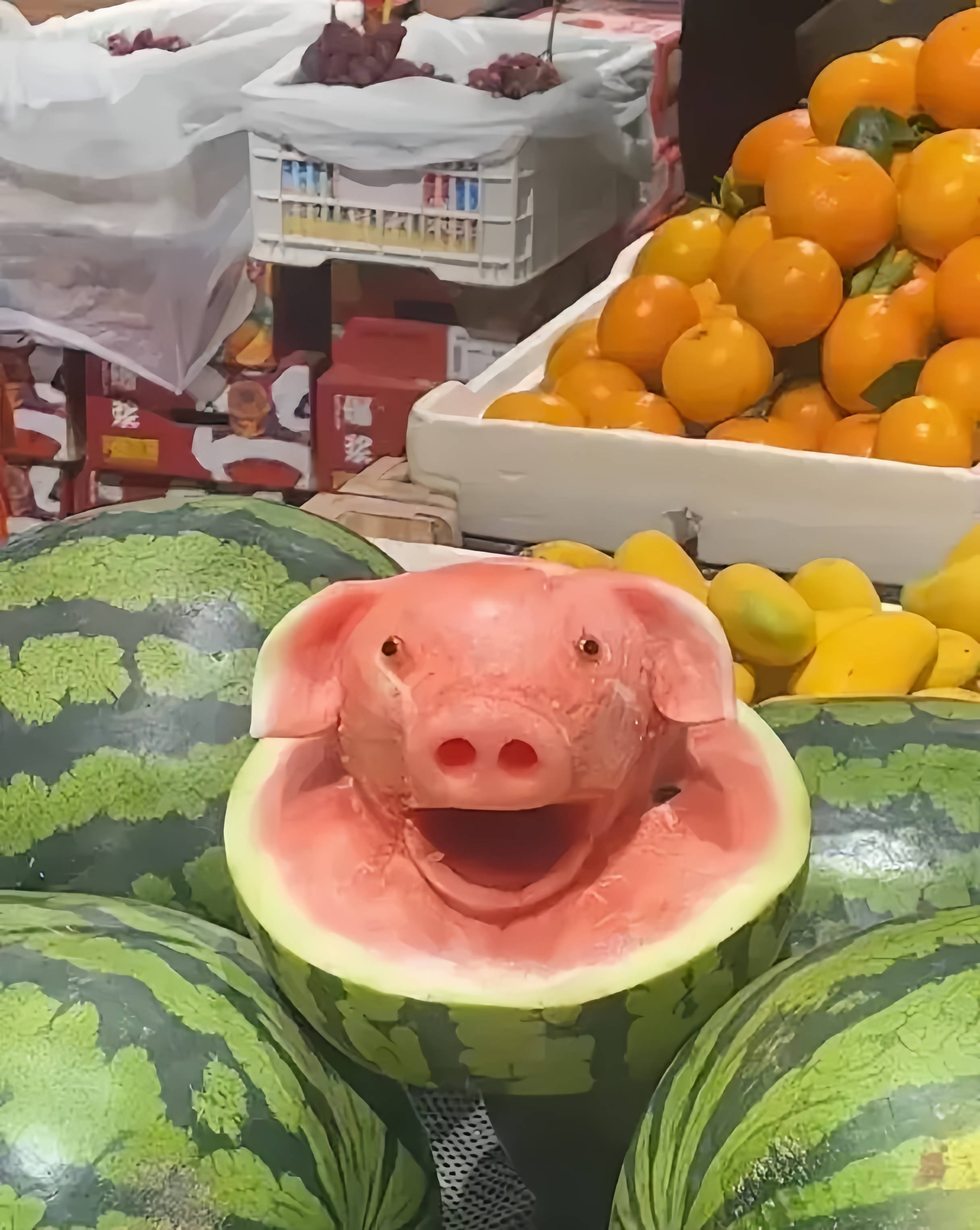 去水果店买东西,看见一个大西瓜,被雕刻成了一只会笑的猪头,可见店