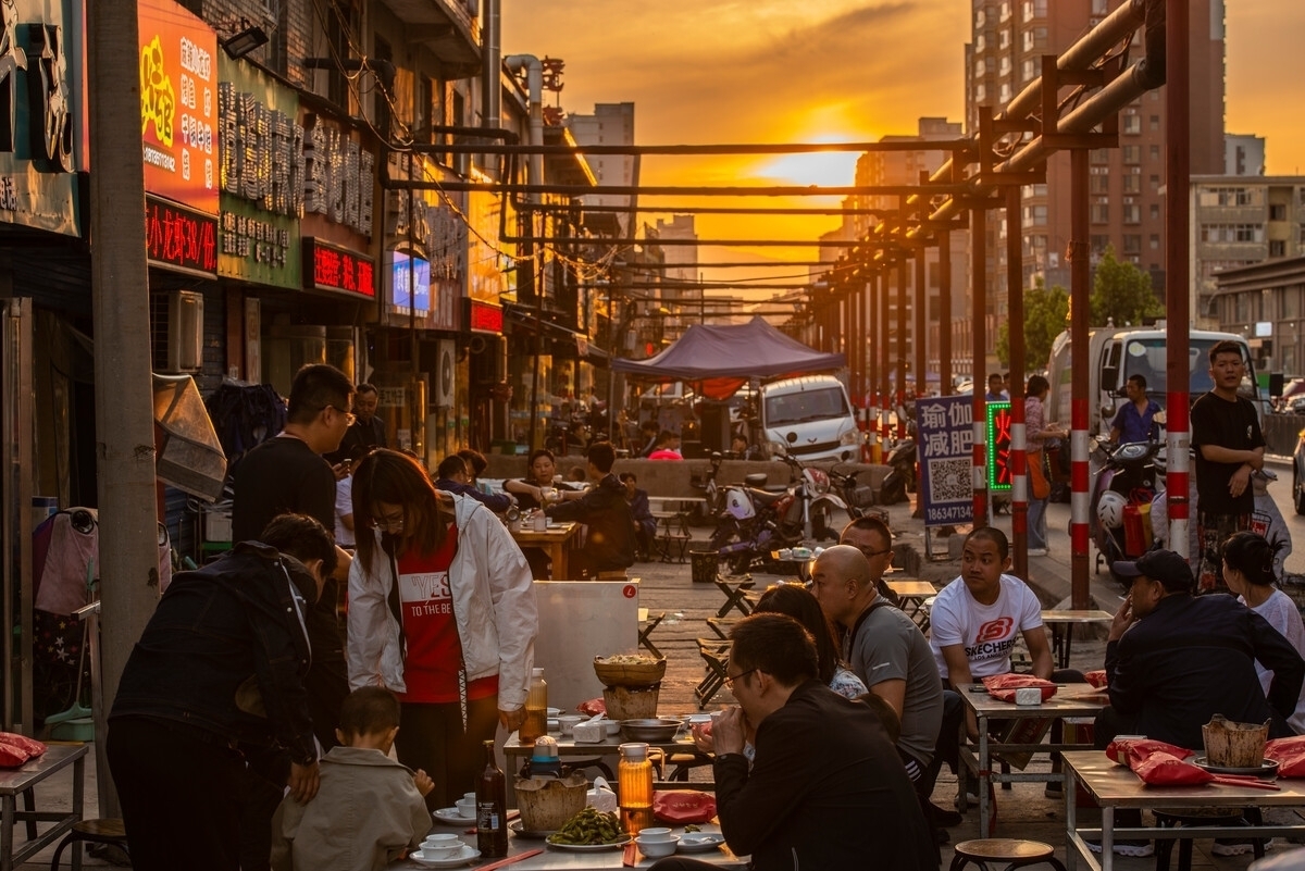 这是一条充满生活气息的街道,路两旁摆满了摊位,琳琅满目的商品让人目