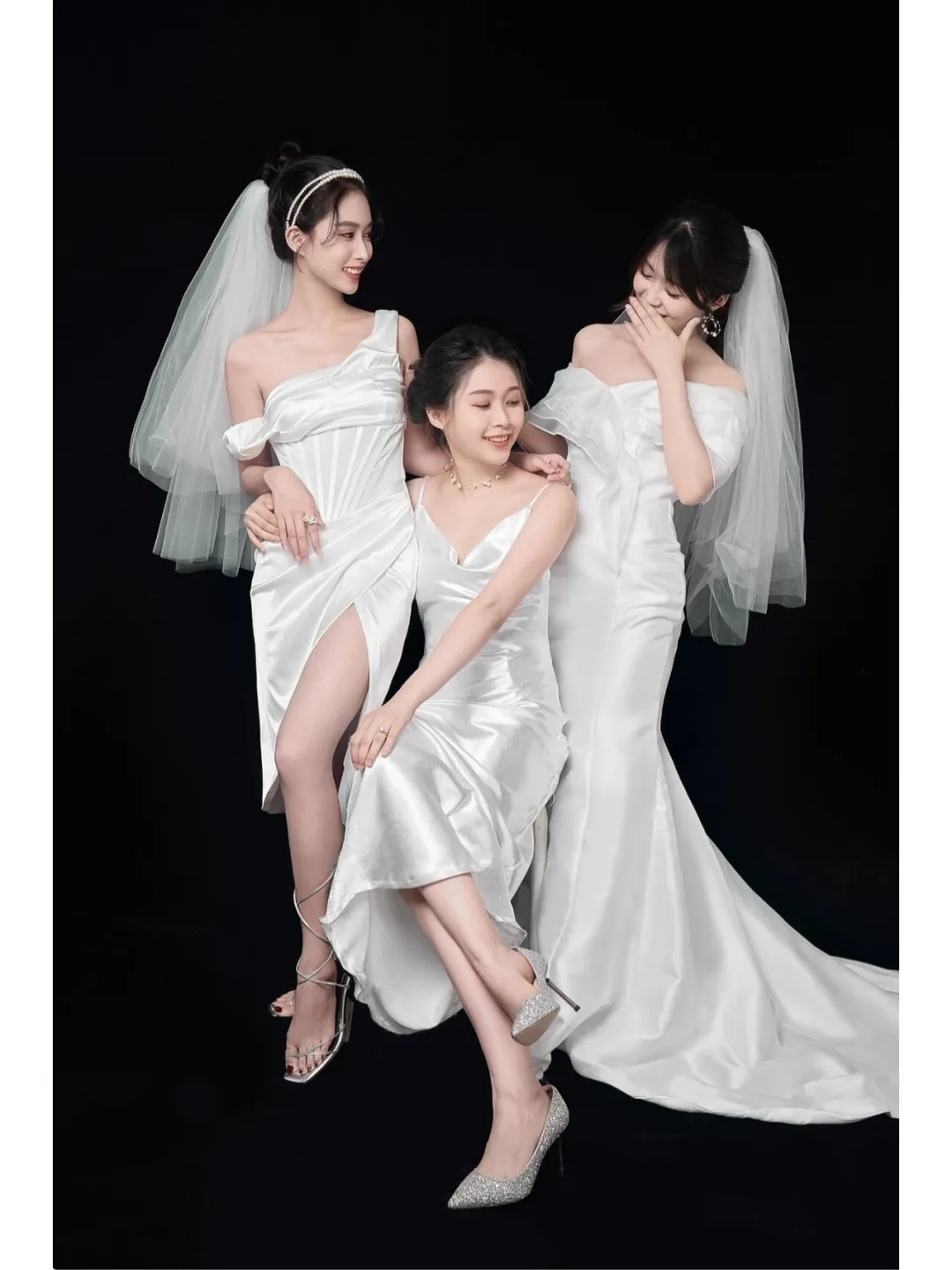 三姐妹身穿白色礼服,笑容甜美,在黑色背景下显得更加亮眼