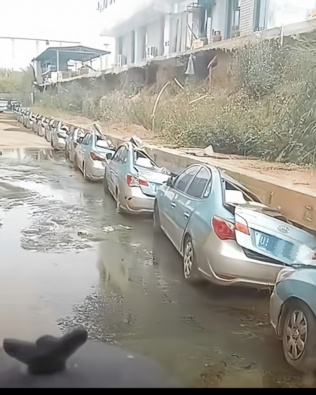 眼前这一排排小汽车整齐停在墙角下,不料墙角因年久失修,又赶上最近