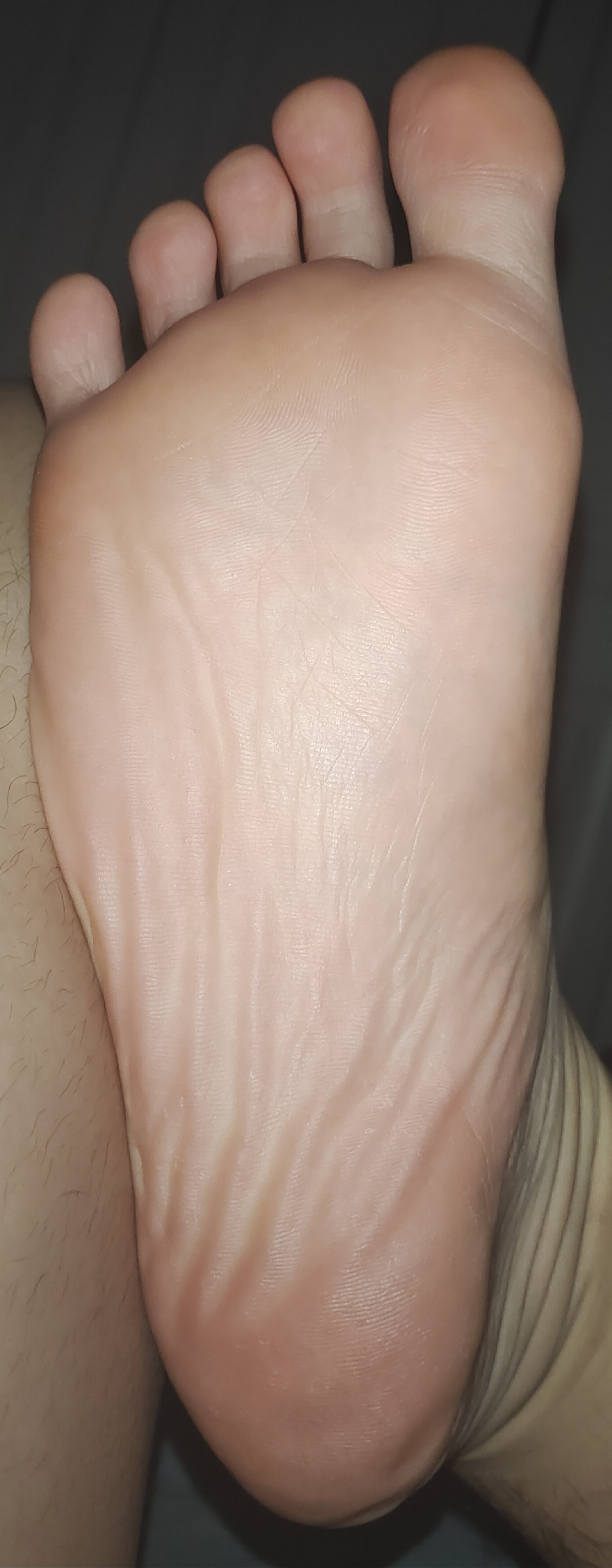 93  这张照片,截取了一只脚的跟部特写,脚底朝上,脚趾伸直,呈现出一