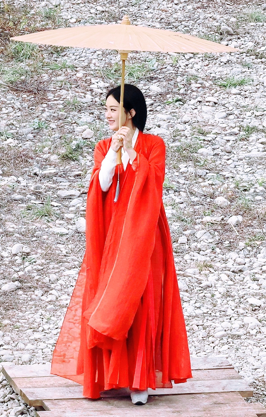 红衣撑伞步轻盈,美人如画雨中行. 伞下风情谁解意,独留倩影入诗心