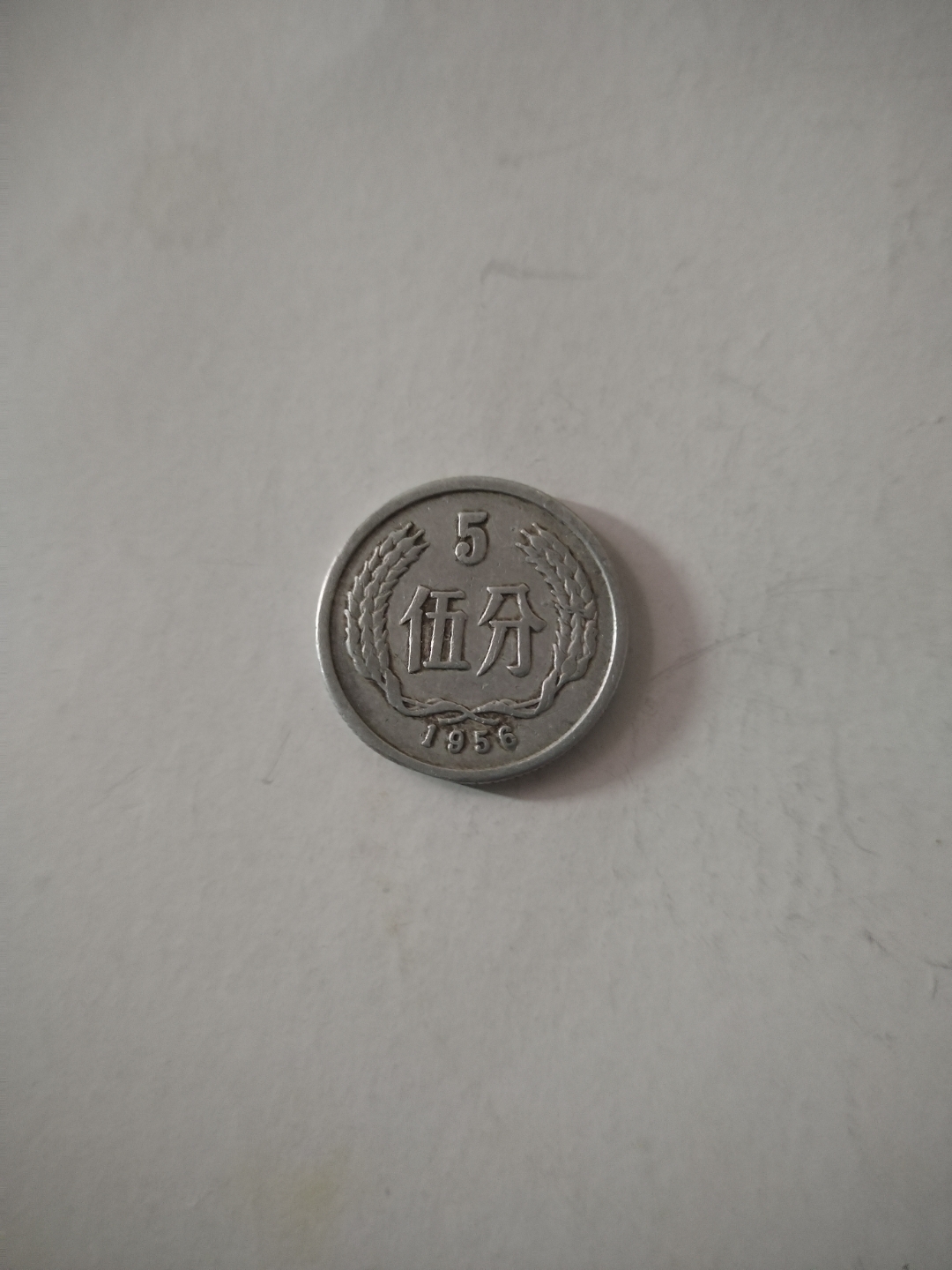 这是一枚1956年的五分硬币,是一枚错版币,你看,右边麦穗中间跟其他的