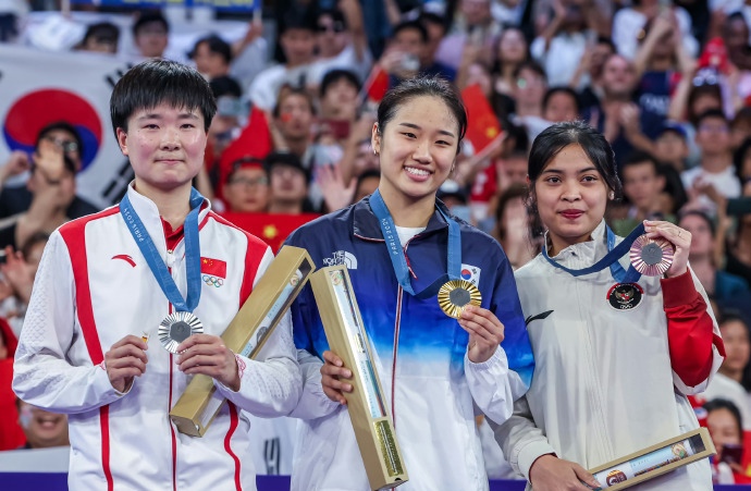 在巴黎奥运羽毛球女单颁奖仪式上,有个细节,就是何冰娇,一直手举一枚