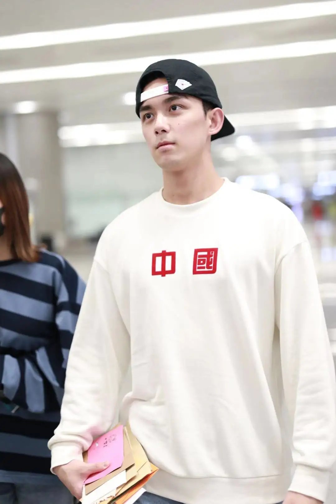 吴磊机场反戴棒球帽变阳光少年,穿中国字样卫衣更显清爽帅气!