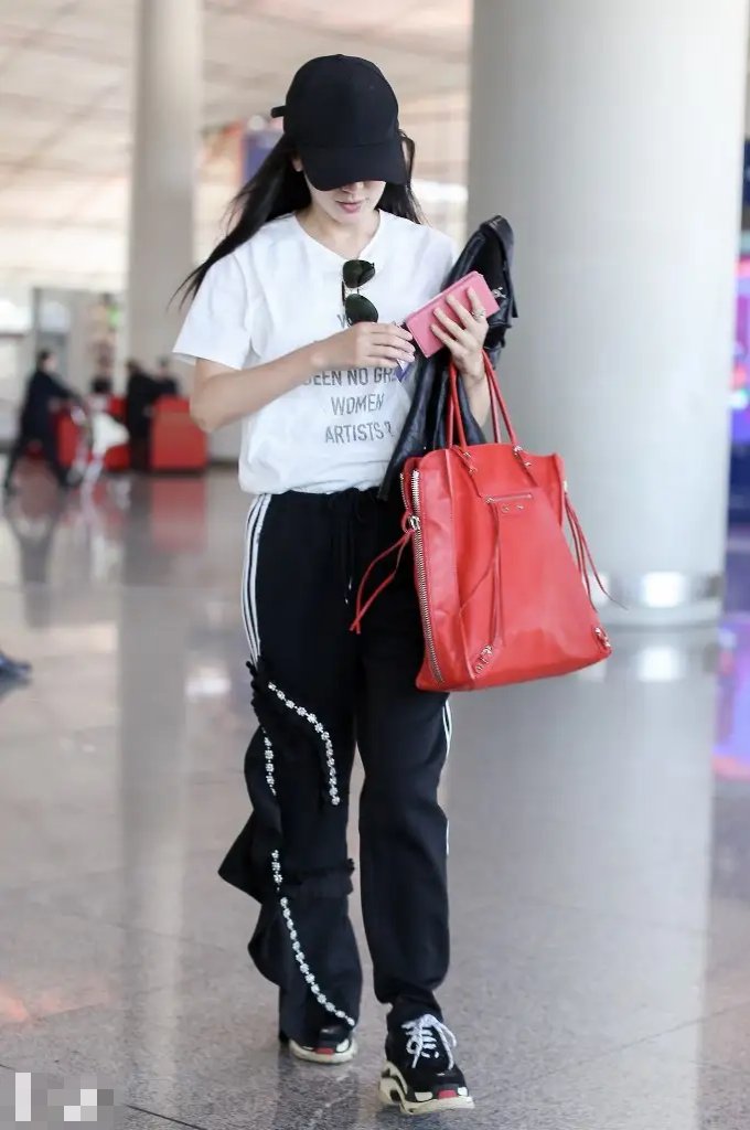 娄艺潇穿白色字母t恤,配黑色开衩运动裤,走机场,走路带风,潇洒帅气!