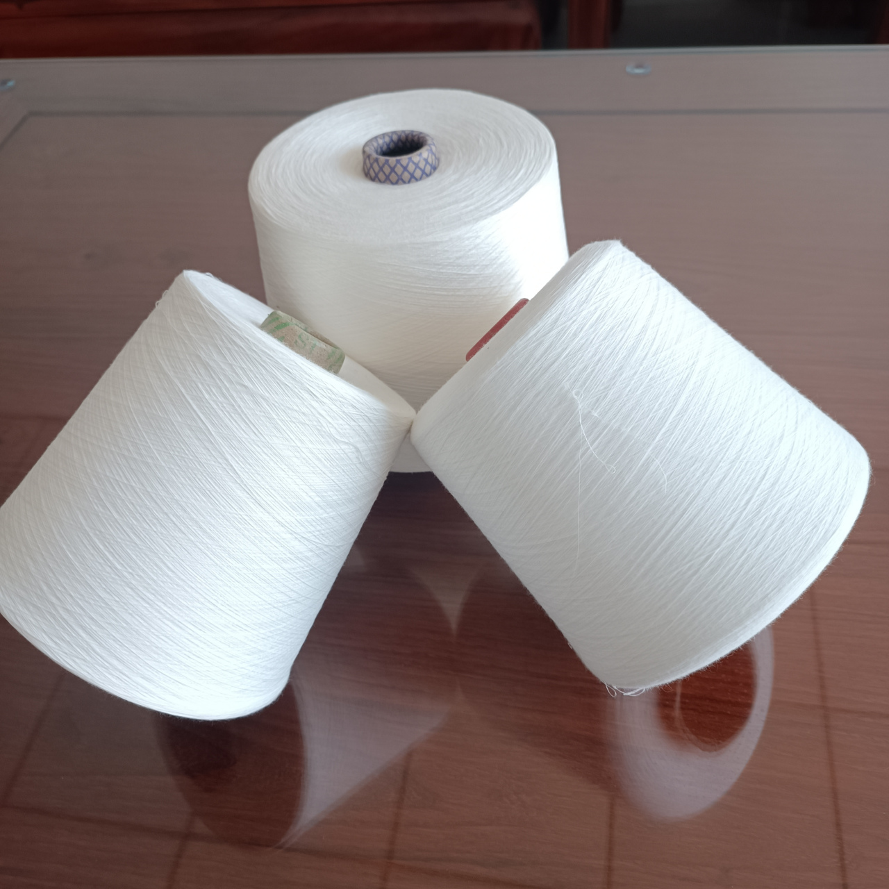 再生涤纶短纤纱是指利用涤纶布料,废旧聚酯瓶片,纺丝废丝,泡泡料,浆块