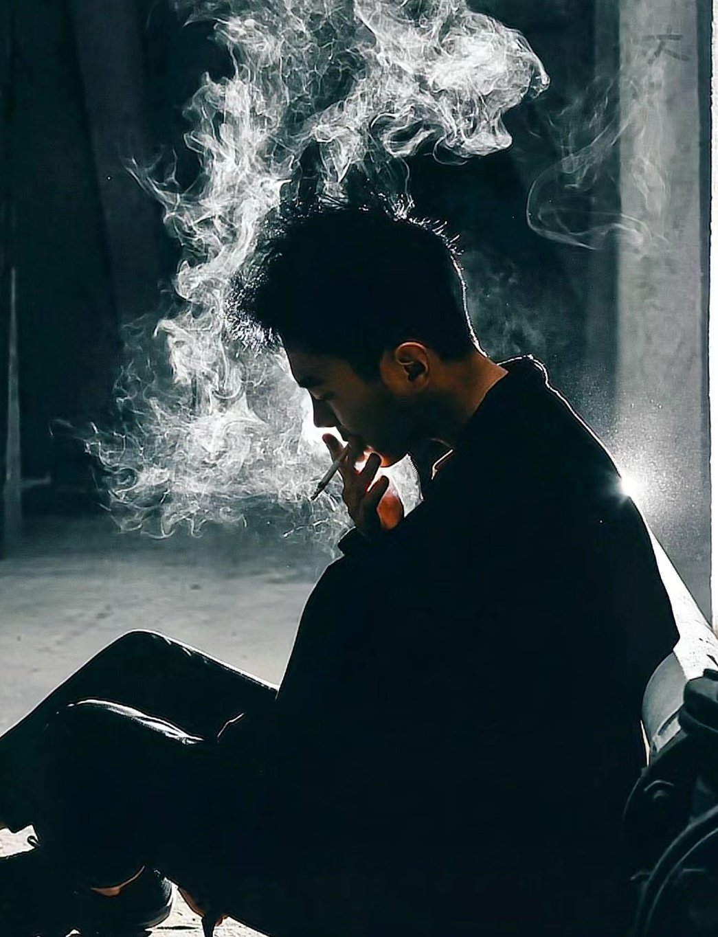 他的面孔被烟雾所笼罩,给人一种神秘而又深沉的感觉