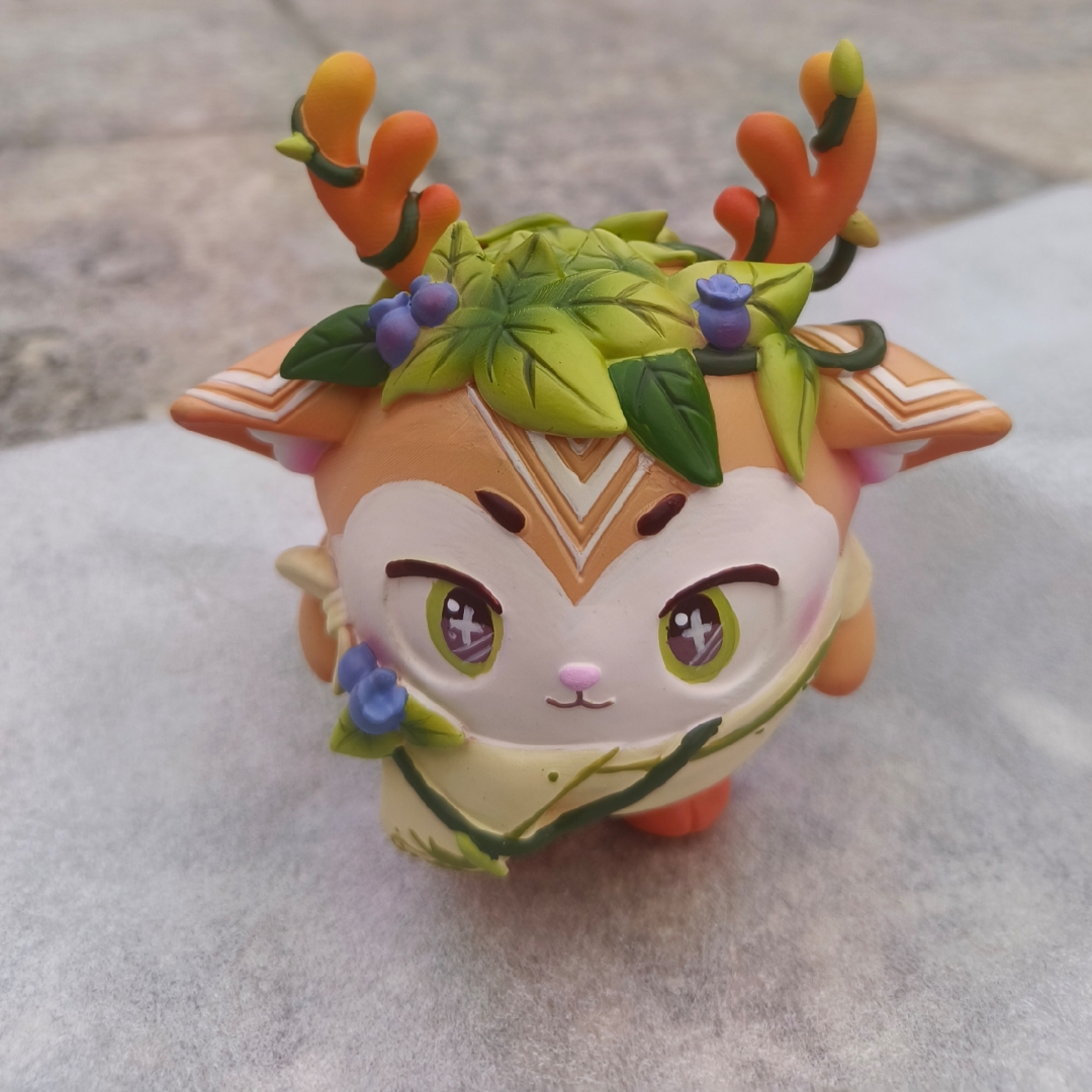 "瞧这只可爱的q版小鹿玩具,头上戴着花环,身穿绿色和黄色的毛衣,胸前