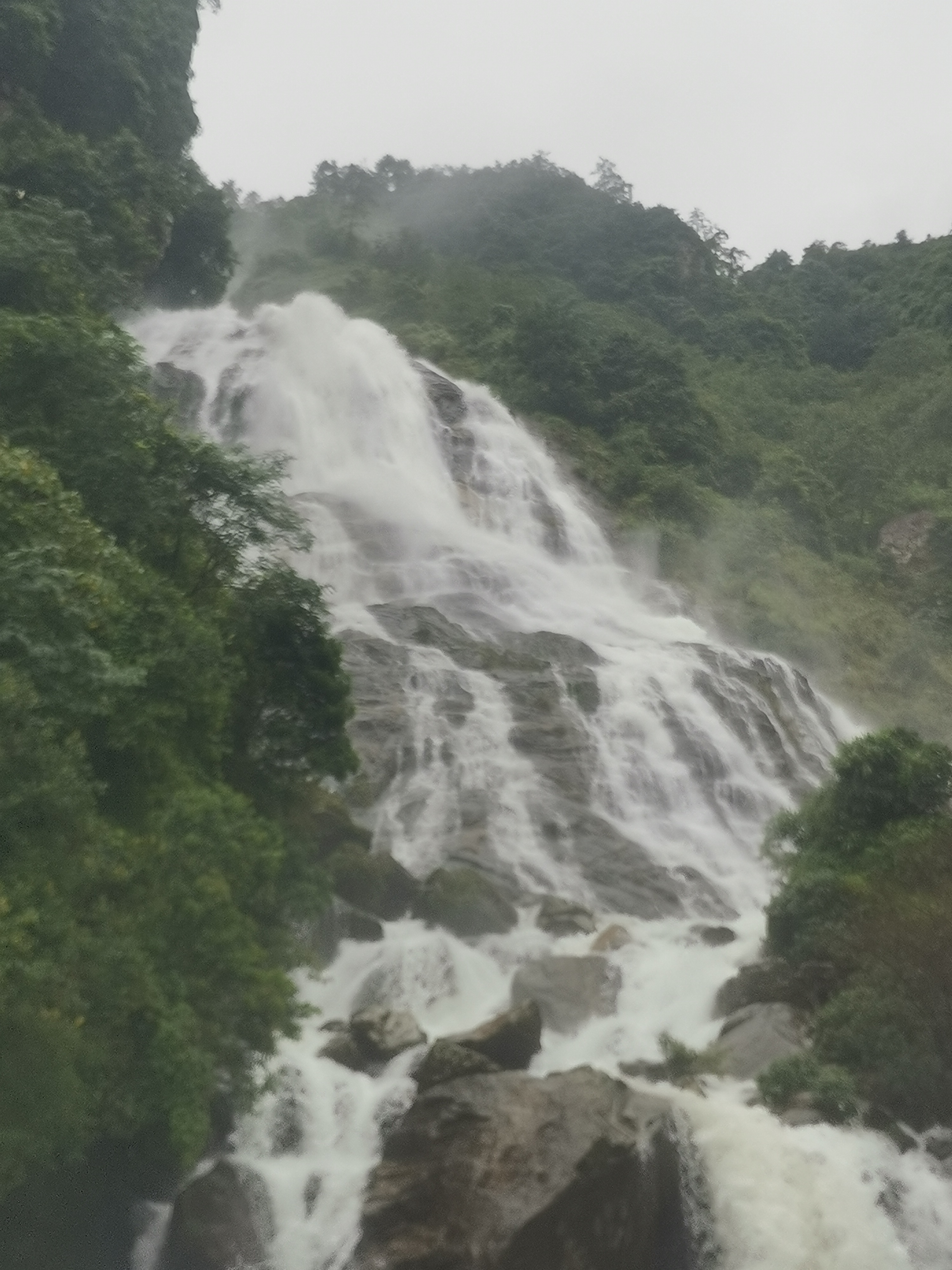 瀑布如白练般垂挂山间,水声轰鸣,震耳欲聋.
