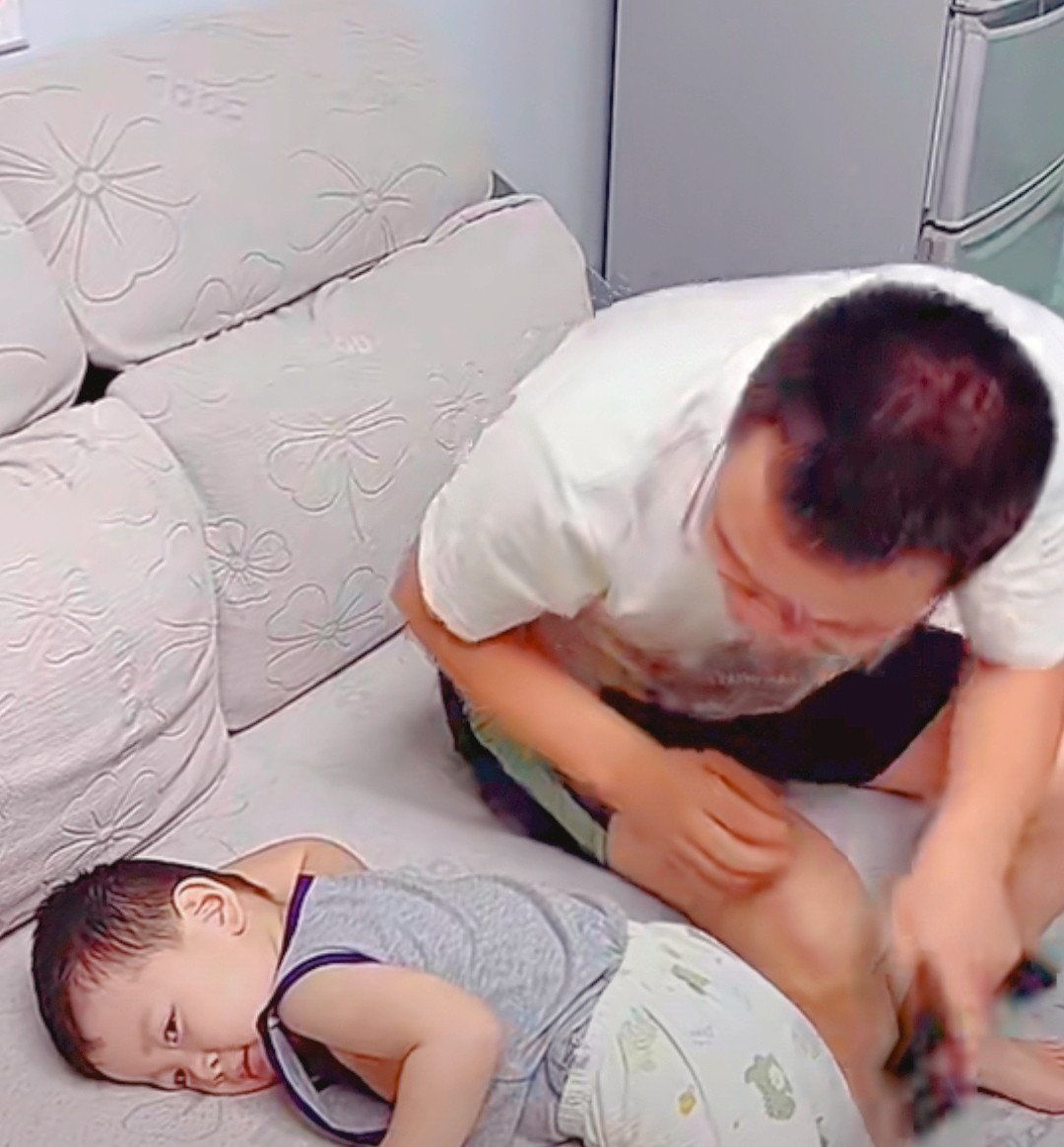 嘿,您瞧瞧这对父子,爸爸在沙发上睡个觉,被三岁儿子一巴掌打醒