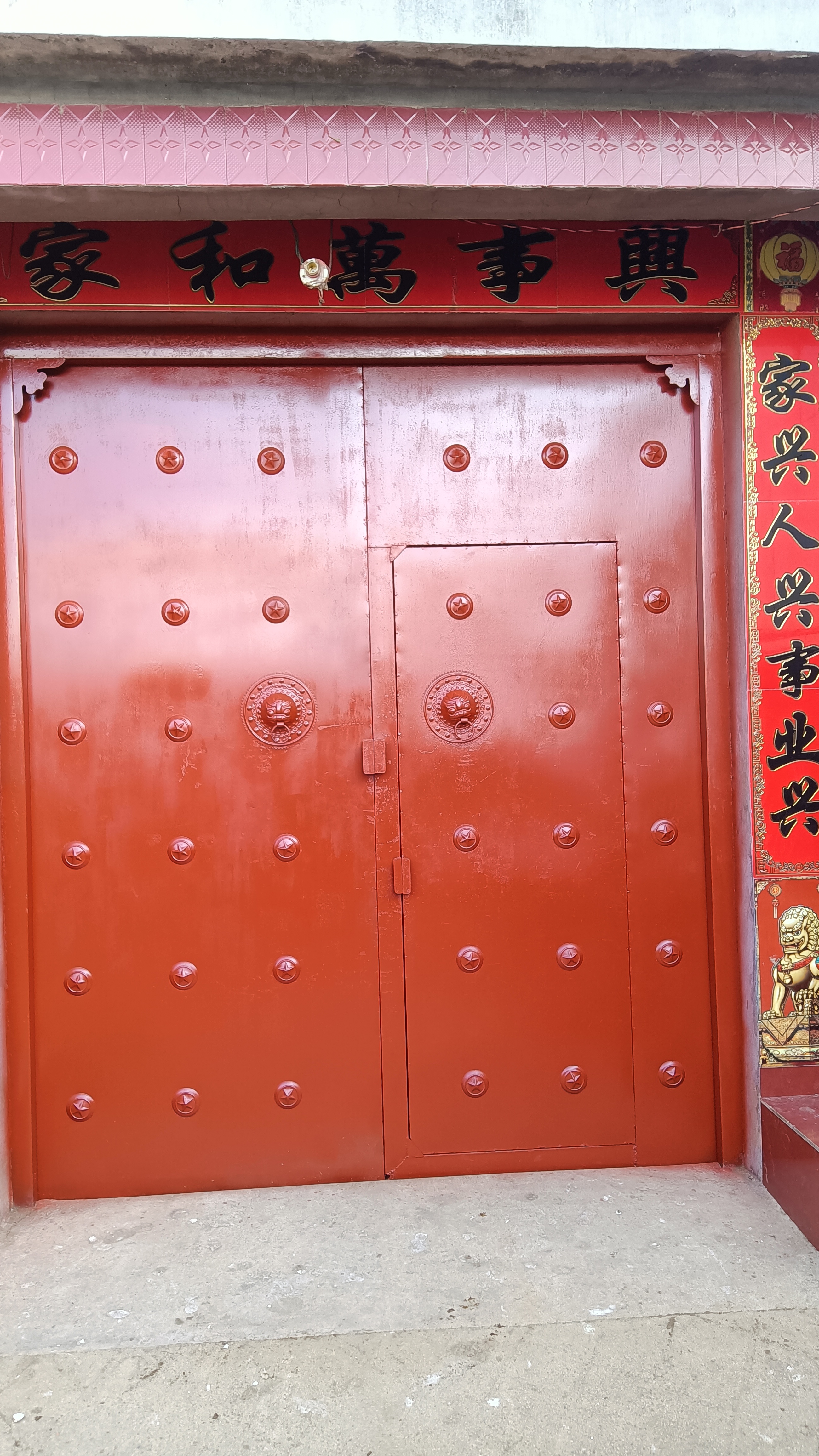 大门喷漆 家和万事兴,红色大门寓意着幸福美满,圆形金属装饰增添了