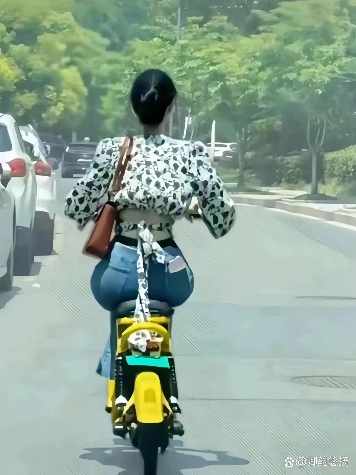 这位小姐姐骑着一辆黄色电动车翩然而至,身姿轻盈,风采动人.