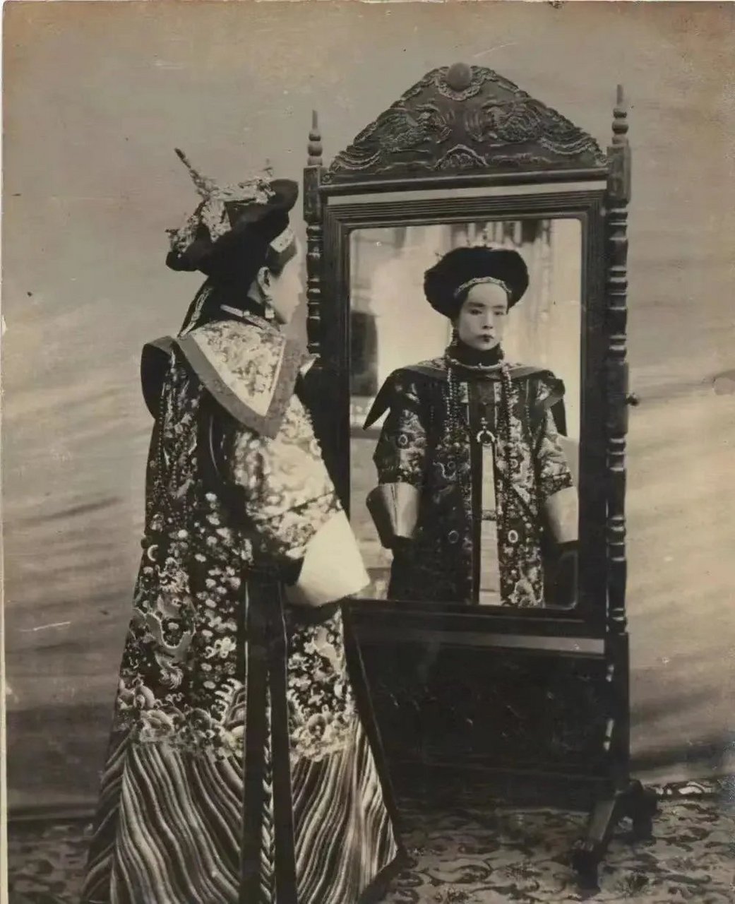 这张照片拍摄于1908年11月29日,北京禁城里,肃亲王王妃穿着朝服正在照